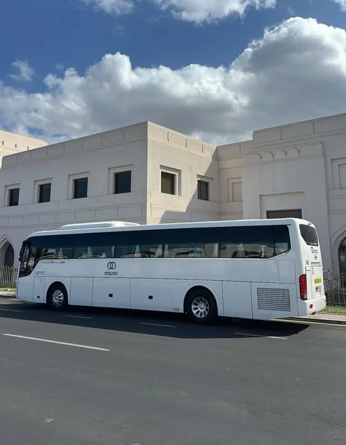 حافلة مسار السياحية البيضاء أمام مبنى